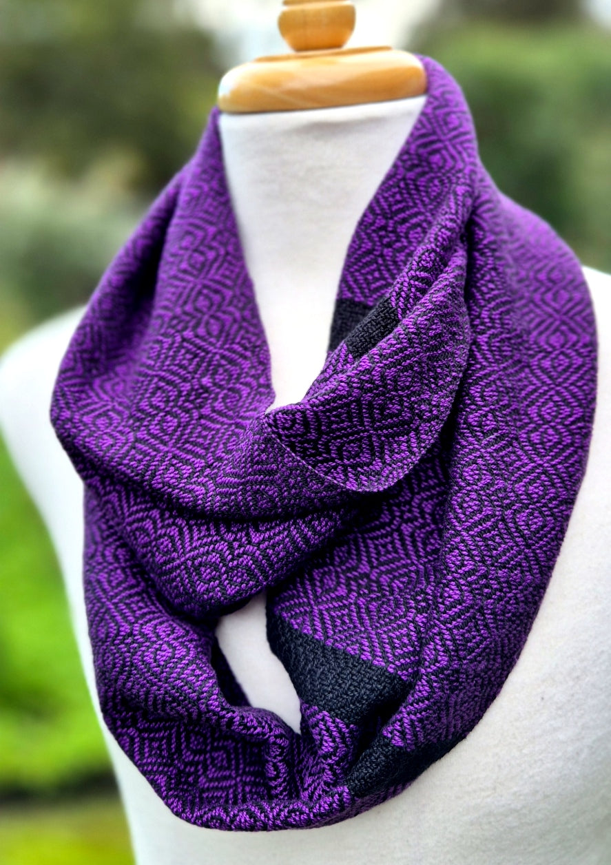 Purple patterned scarf on a mannequin with a blurred green background