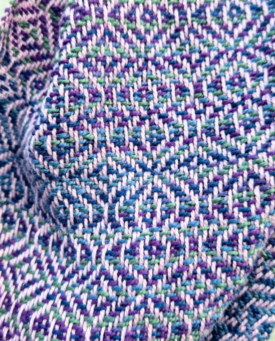 detail of handwoven infinity scarf in shades of purple, light pink and blue