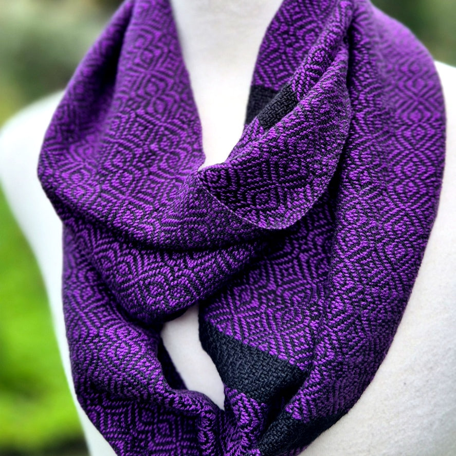 Purple patterned scarf on a mannequin with a blurred green background