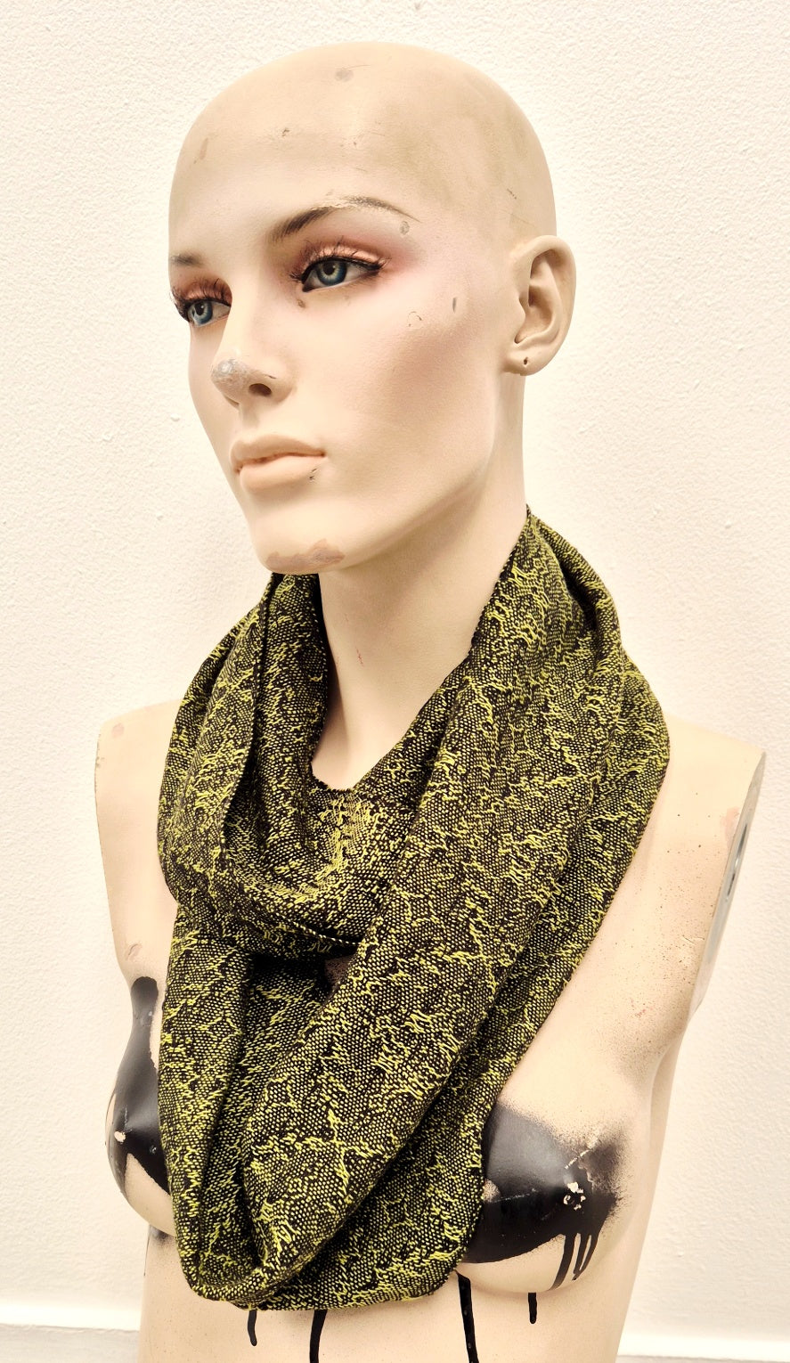 mannequin wearing fine handwoven cotton scarf in bright lime green and black