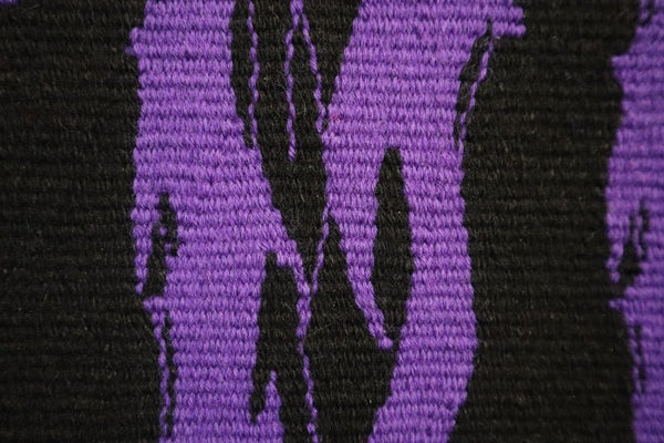 detail of unique artwork of text saying 'queer' in purple death metal typeface font