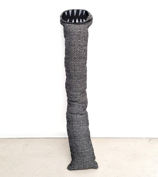 tube creature made with silver and black handwoven fabric with felt teeth