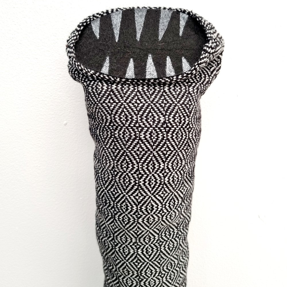 tube creature made with silver and black handwoven fabric with felt teeth