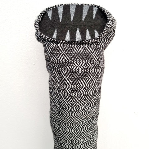 tube creature made with silver and black handwoven fabric with felt teeth