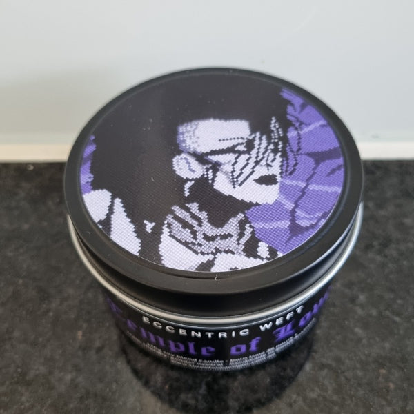 handmade soy candle with artwork of jonny slut specimen on lid - teak neroli tobacco hay goth candle