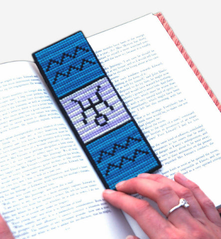 cross stitch pattern of a bookmark with zodiac signs of Aquarius and Uranus