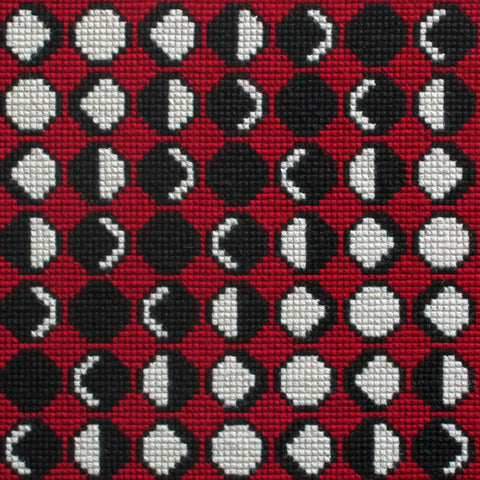 needlepoint of the phases of the moon in a geometric pattern, black white and red
