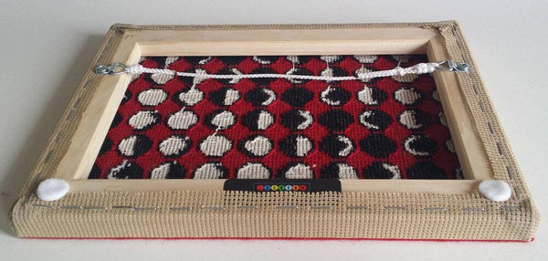 back of needlepoint of the phases of the moon in a geometric pattern, black white and red